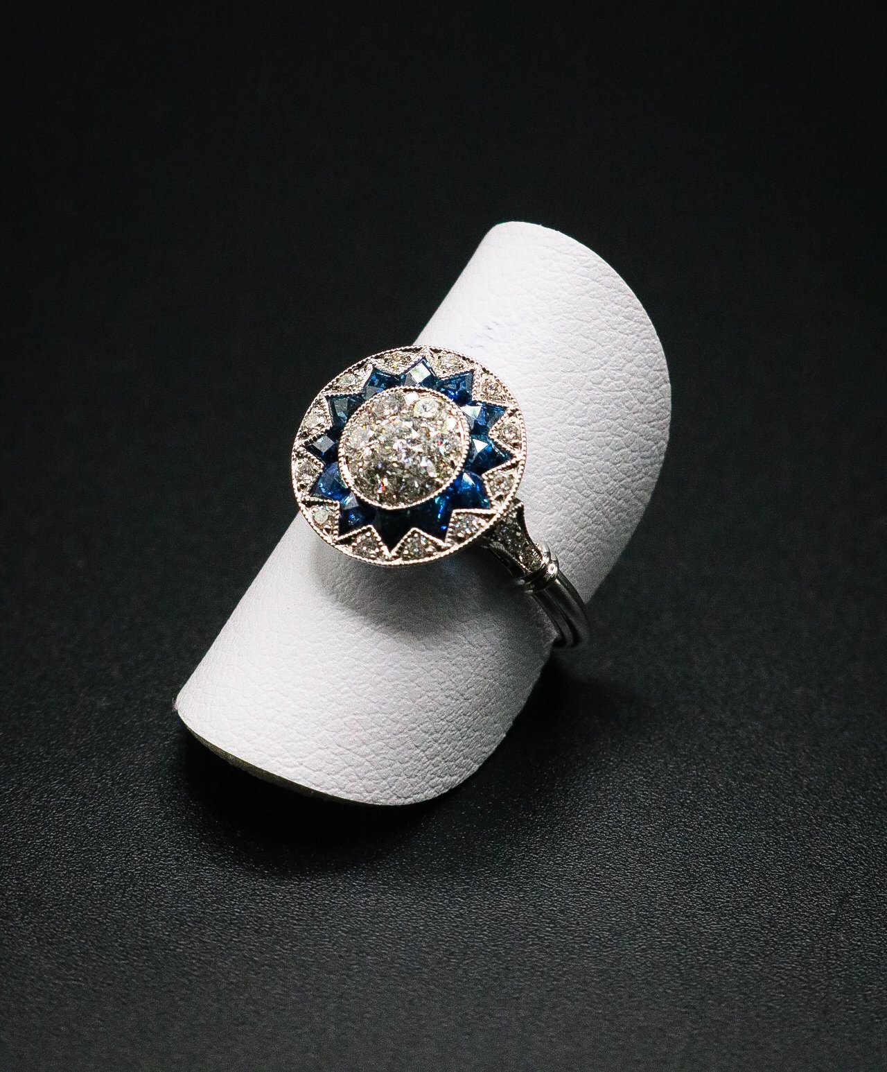 Art-deco style ring with natural diamond cluster center and blue sapphire starburst border