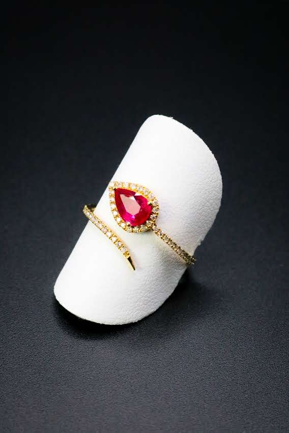 Gold wrap ring with pear-shaped ruby and diamond halo trailing along the band